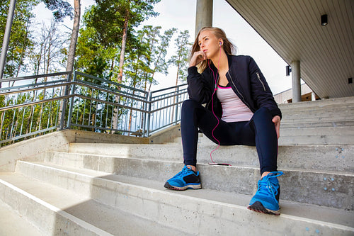 Thoughtful Young Woman In Sportswear Sitting On Steps