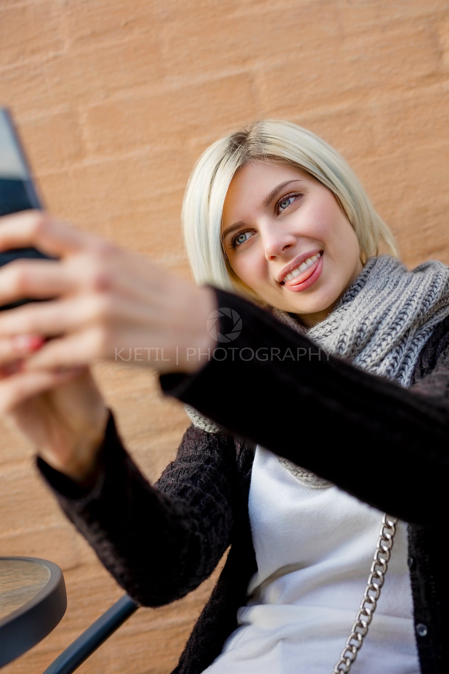 Woman Making Faces While Taking Selfie At Outdoor Cafe