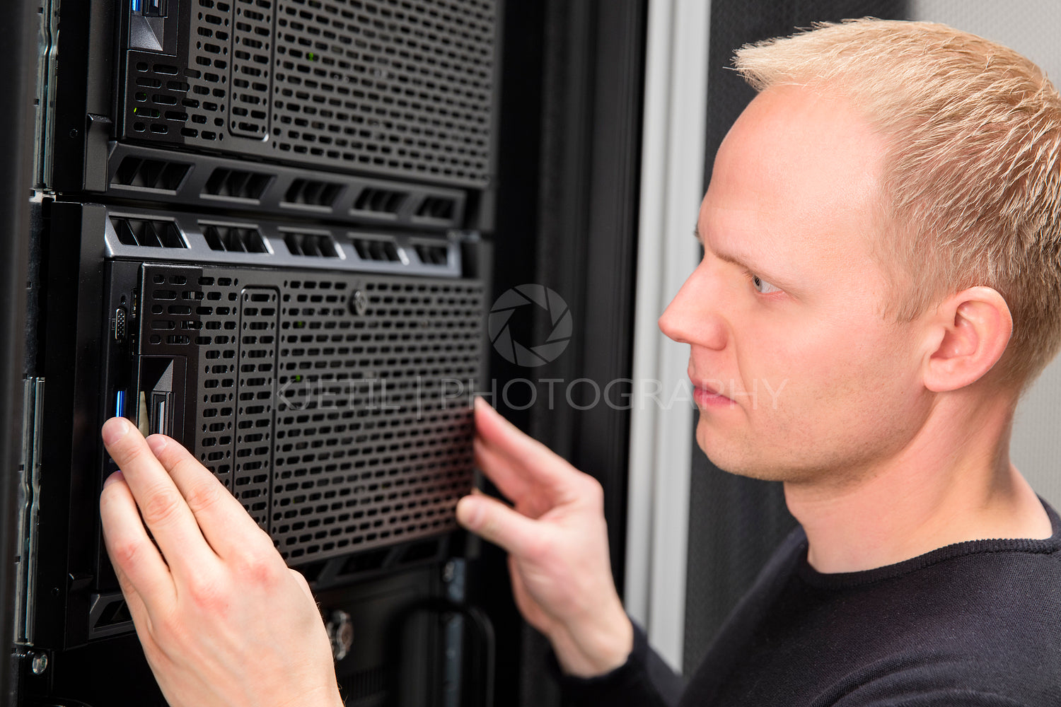 Close-up of It consultant installing server in datacenter