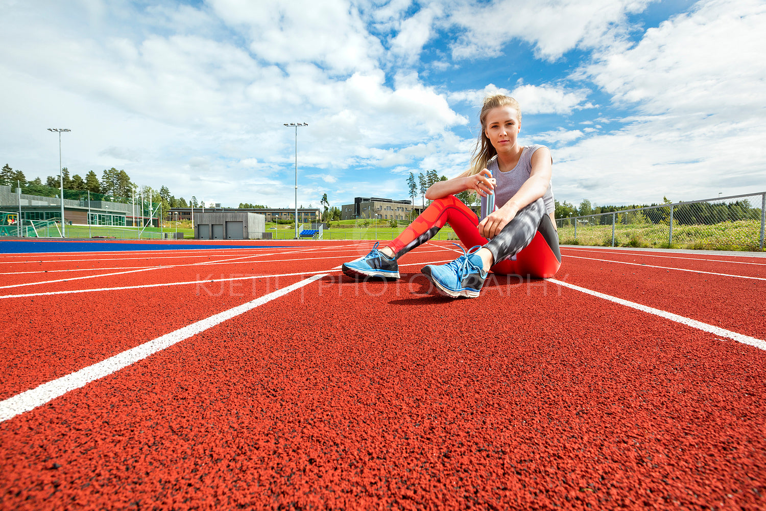 Young Woman Holding Water Bottle On Running Tracks