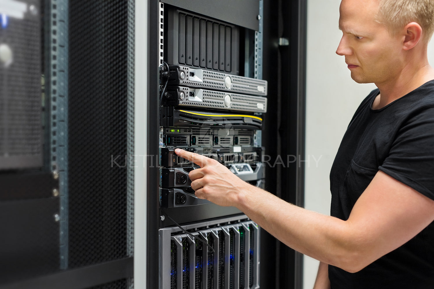IT Technician Monitors Server On Rack In Datacenter