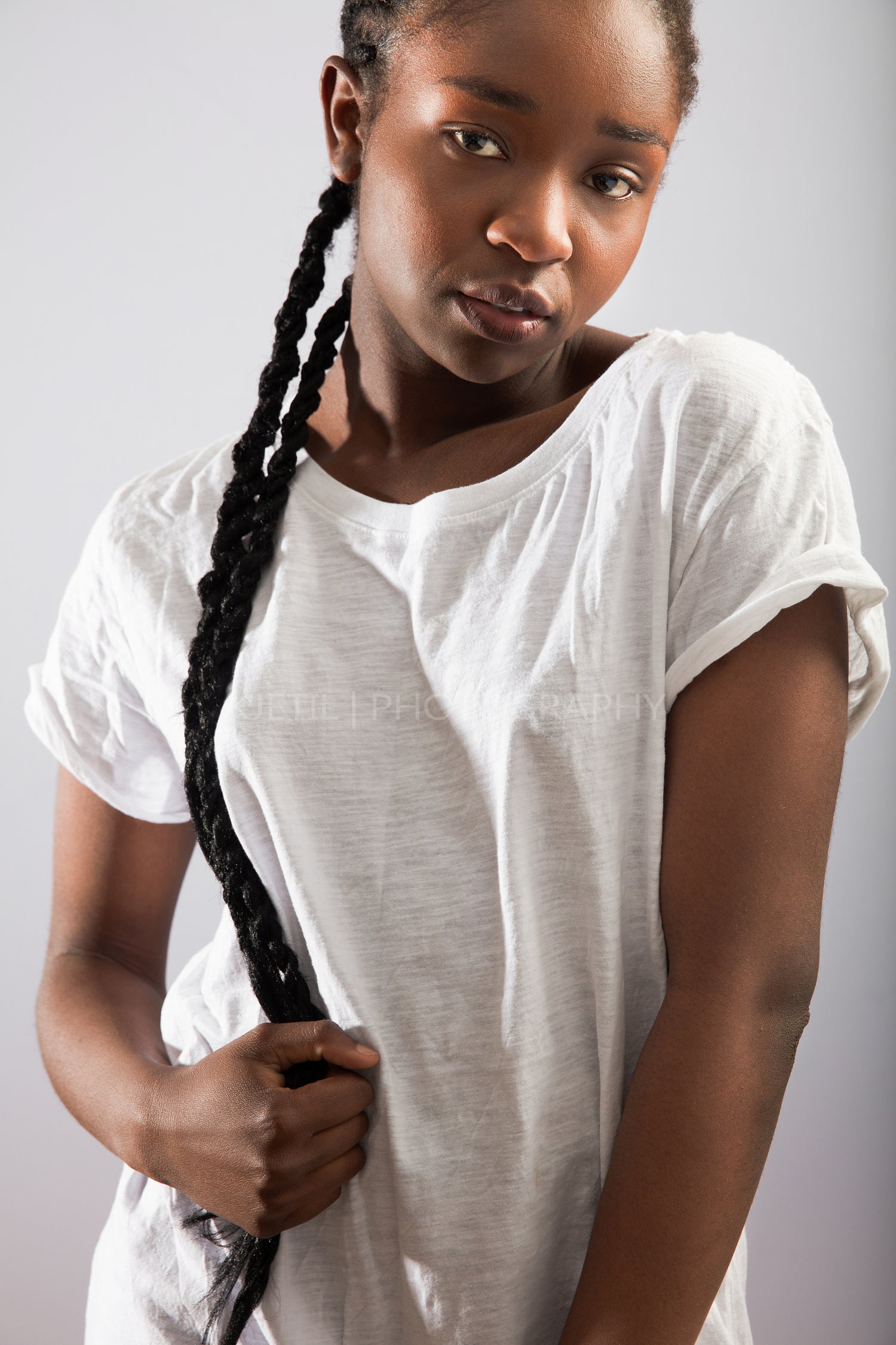 Confident Woman With Braided Hair Over Gray Background
