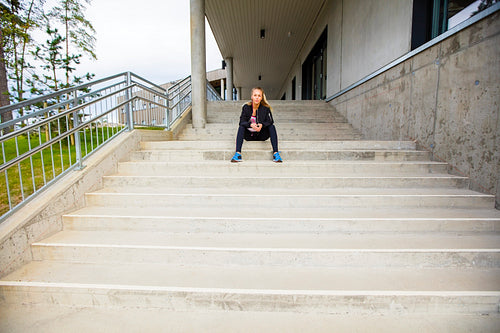 Sporty Young Woman Sitting On Steps After Workout