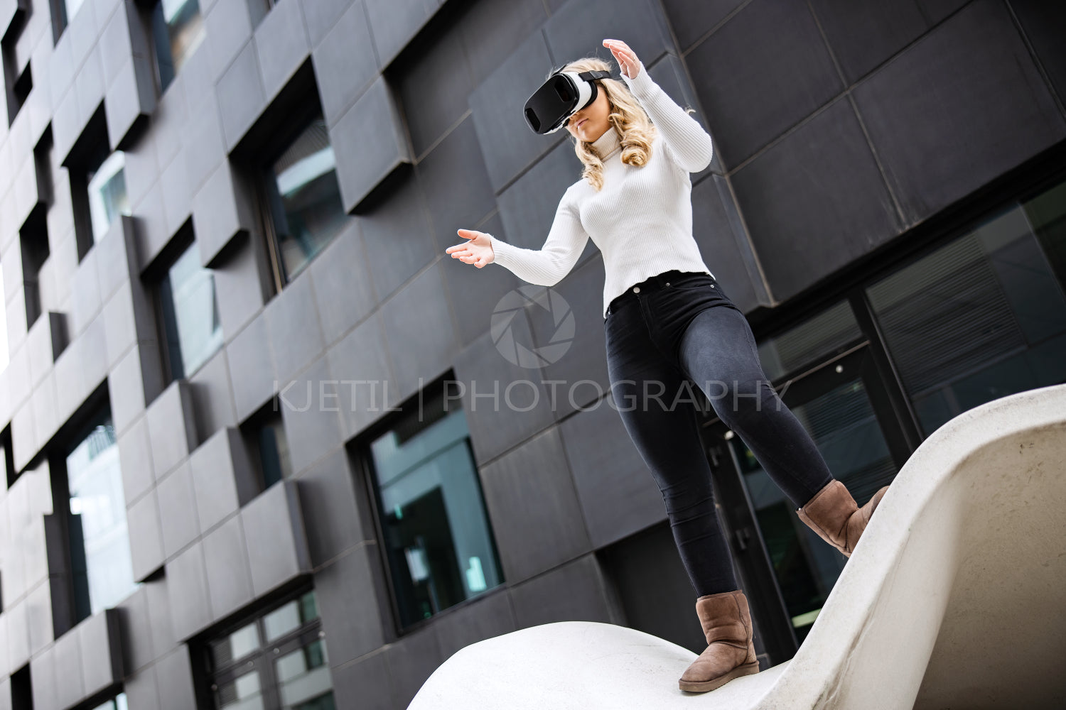 Young Woman Wearing Virtual Reality Glasses Against Futuristic Building