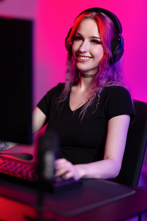 Professional smiling esport gamer girl live streaming and plays online video game on computer