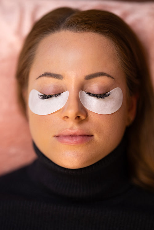 Customer With Cotton Pads During Eyelash Extension Procedure