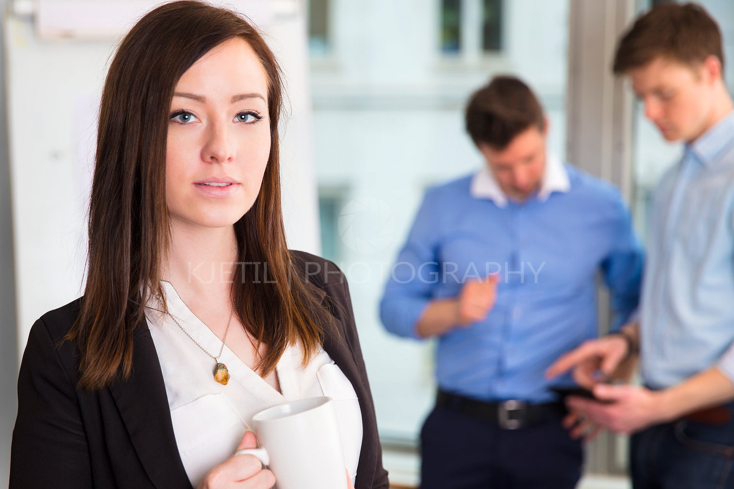 Businesswoman Holding Coffee Mug With Colleagues Discussing In B