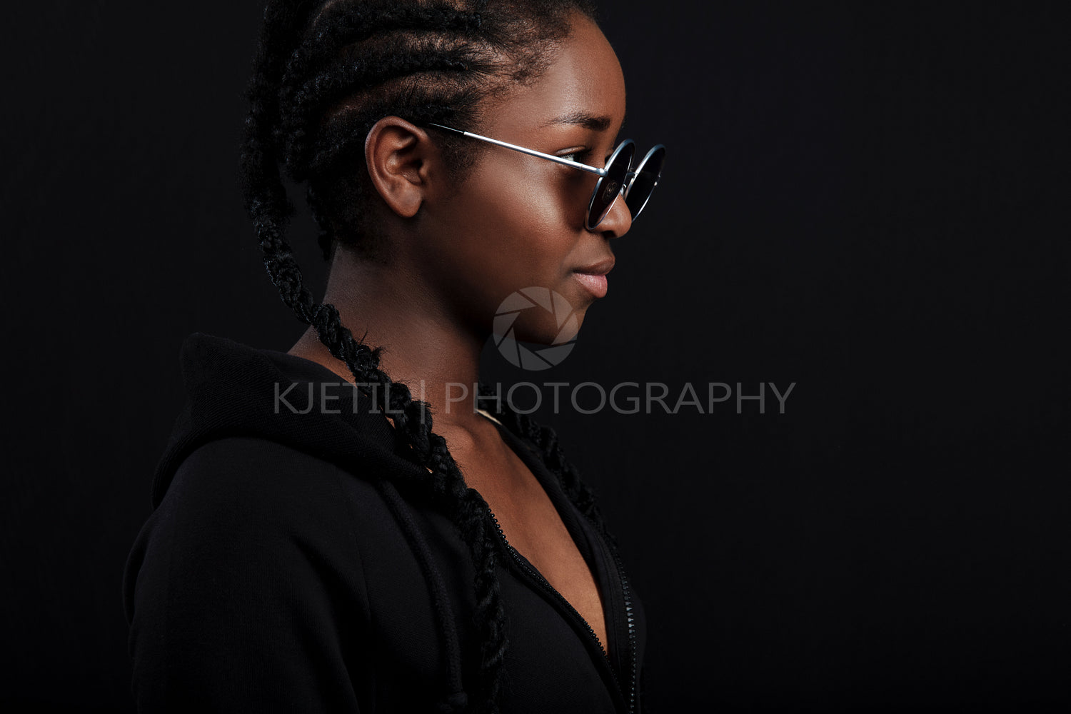 Cool african woman sitting with dark skin wearing round sunglasses
