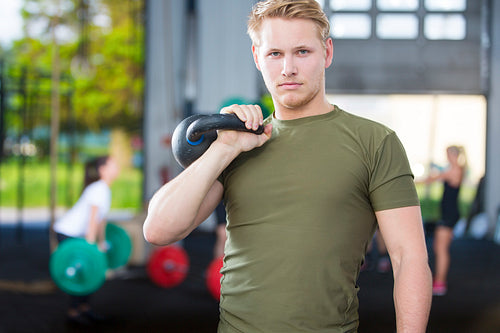 Confident man with kettlebell at fitness gym