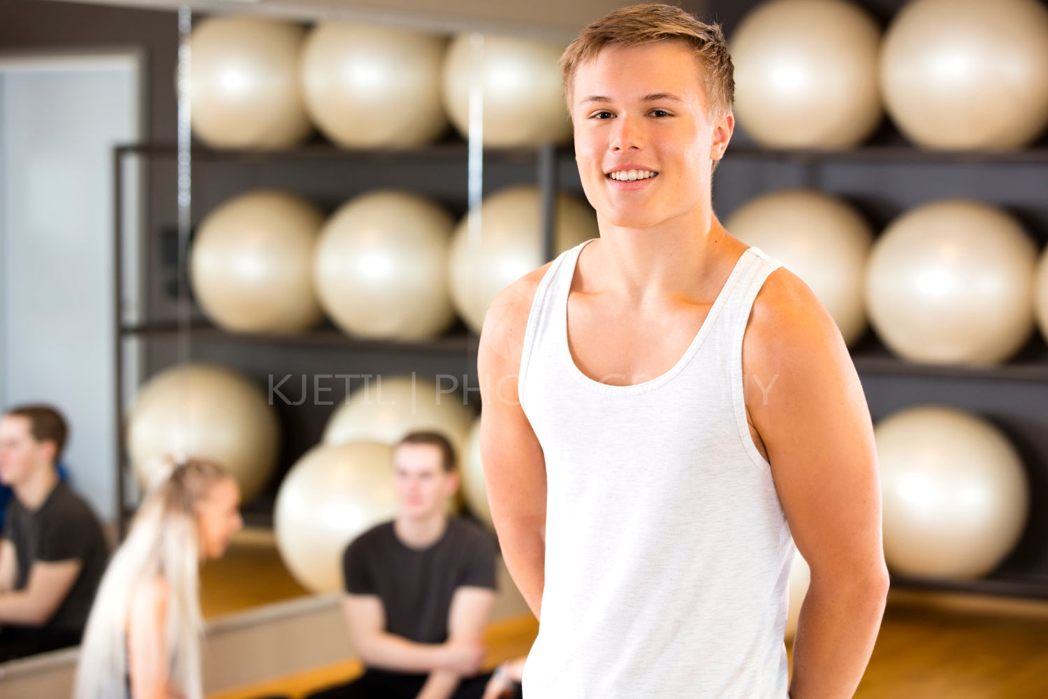 Smiling young man portrait at fitness gym