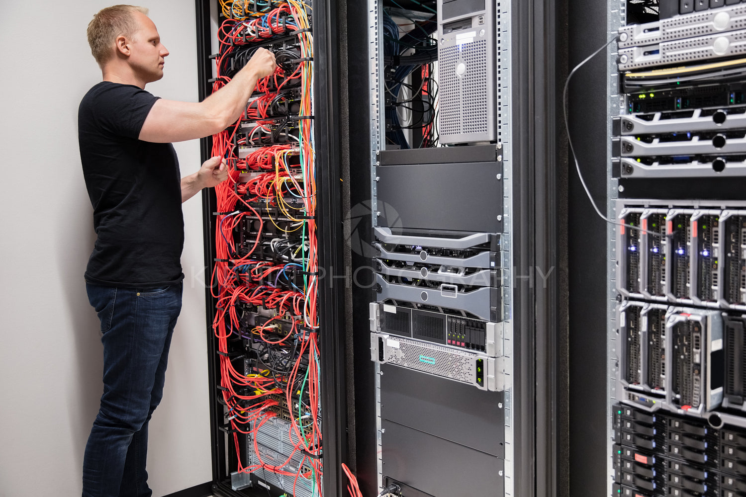 IT Technician Checking With Network Cables Connected To Servers