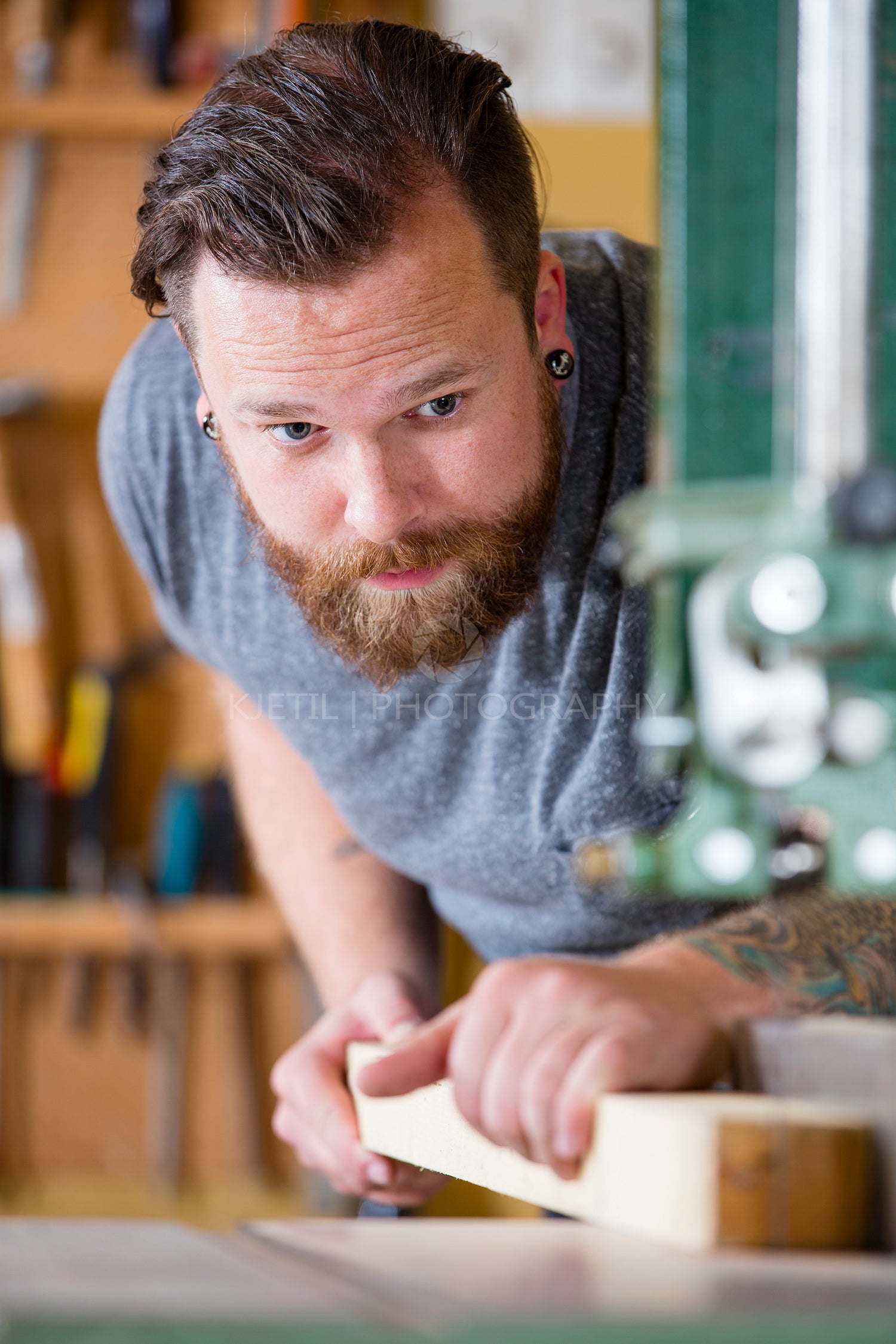 Craftsman using bandsaw for splitting wood plank in workshop