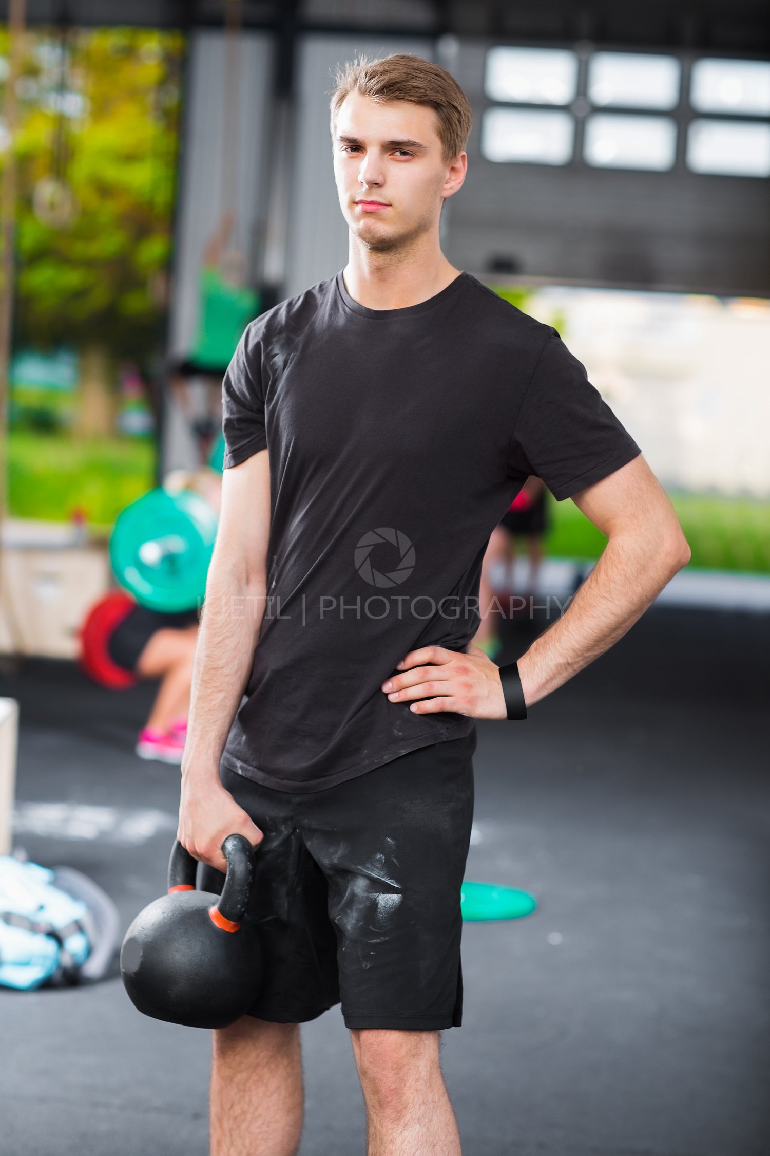 Confident Gym Instructor Holding Kettlebell In Health Club