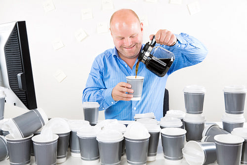 Smiling businessman drinks too much coffee
