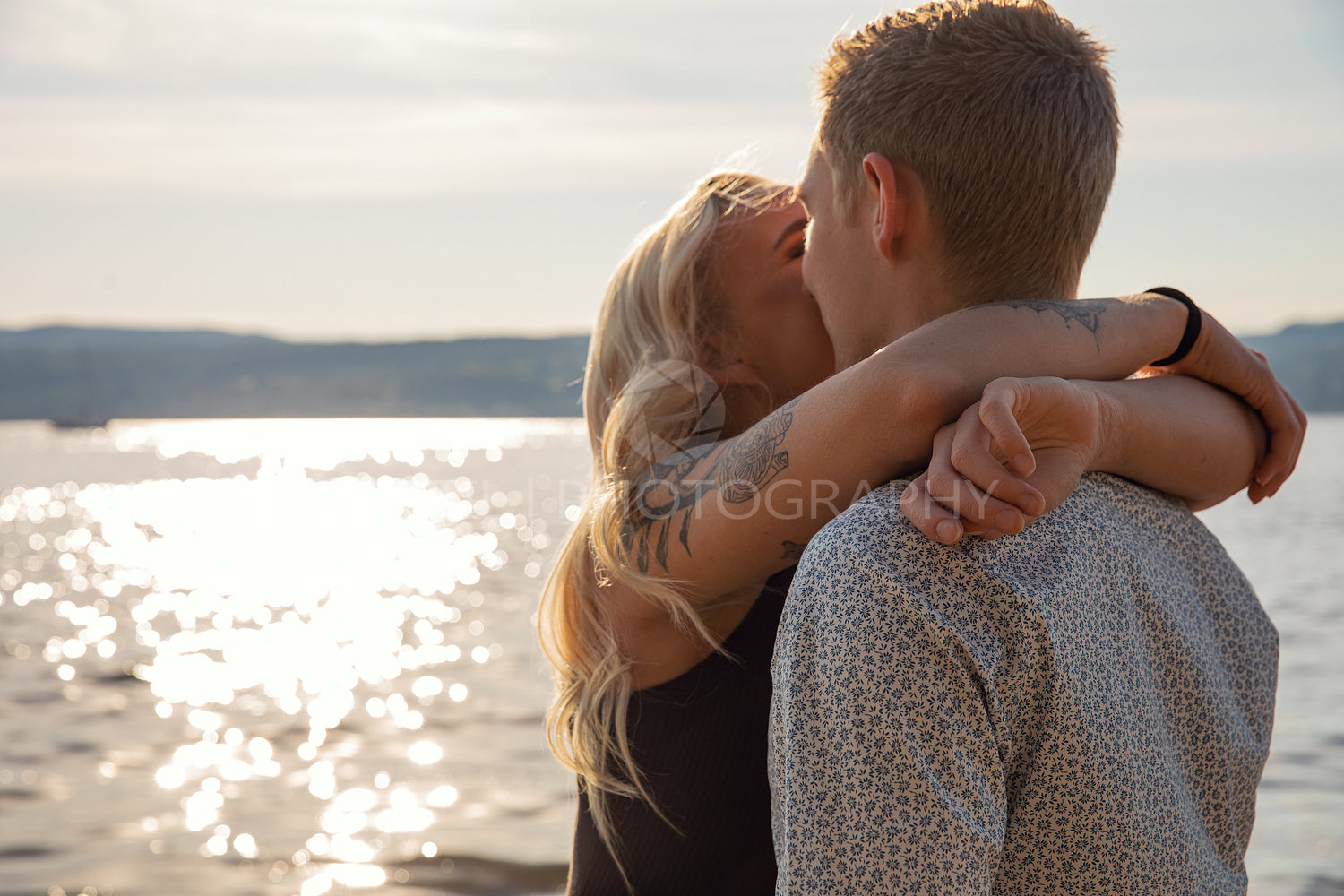 Kissing couple in romantic embrace on beach at summer