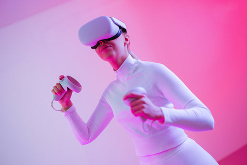 Female in VR glasses against illuminated background