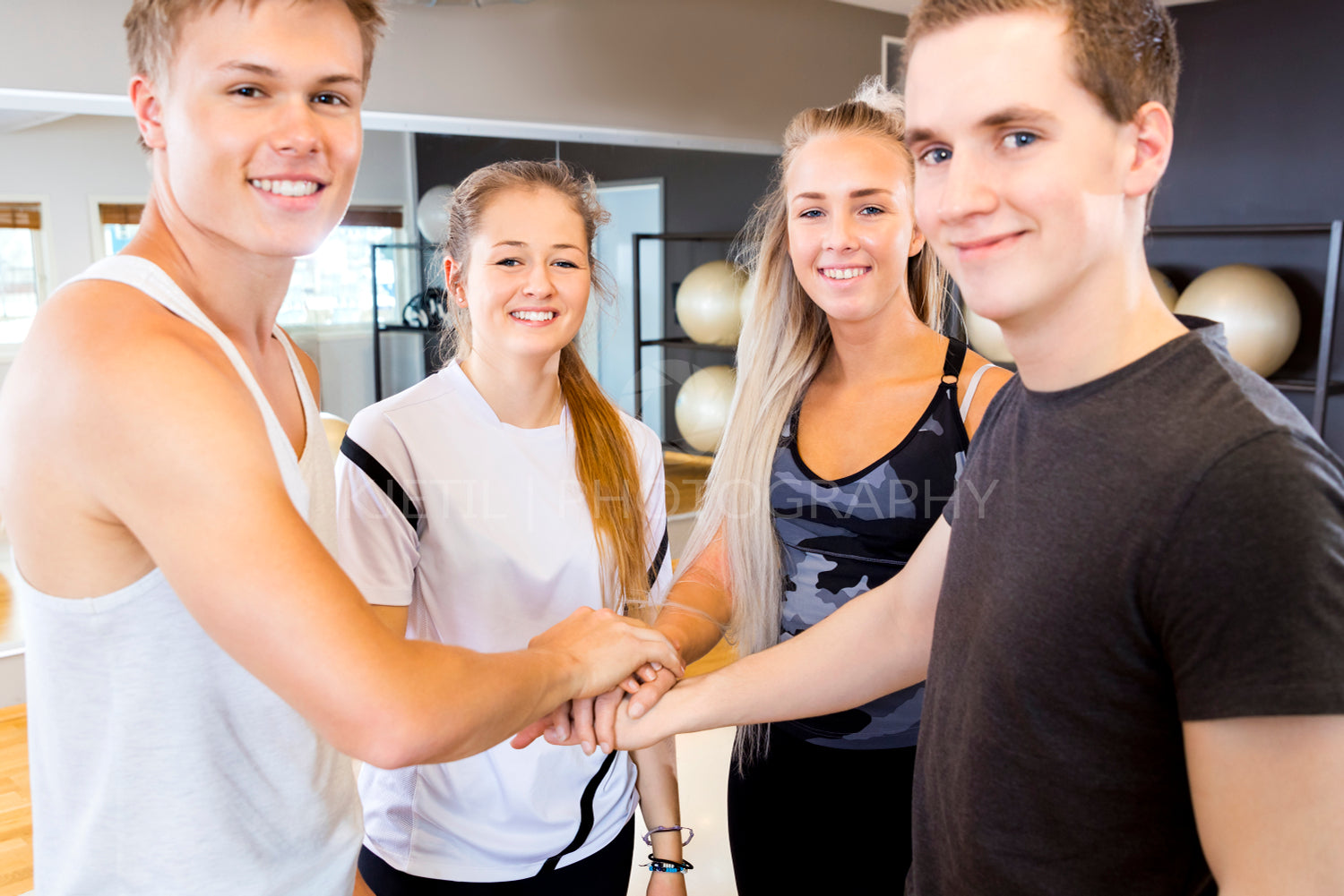Close-up of cheerful fitness workout team holding hands