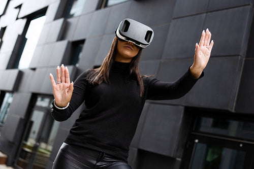 Young Woman Wearing Virtual Reality Glasses And Black Clothes In Futuristic City