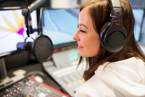 Female Host Wearing Headphones At Radio Studio