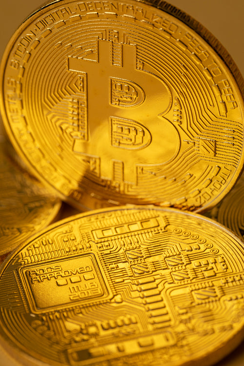 Closeup of gold bitcoin on yellow backgound