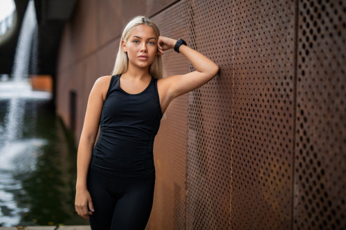 Fit Young Woman Leaning On Metallic Wall After Workout