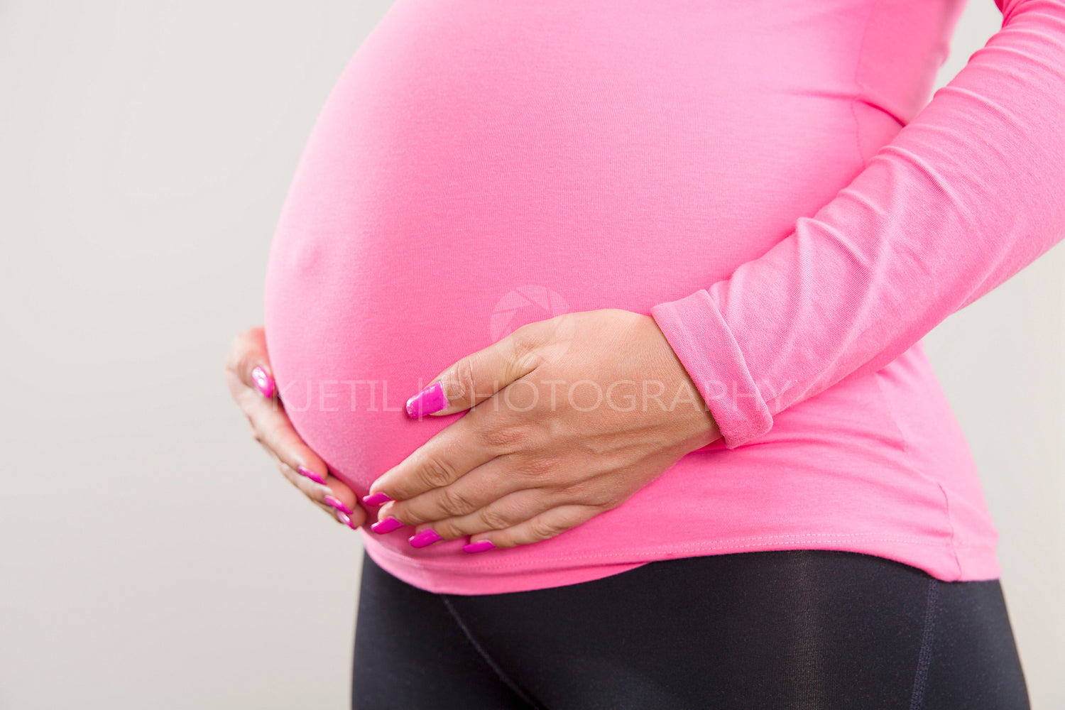 Pregnant woman holds on her swollen belly