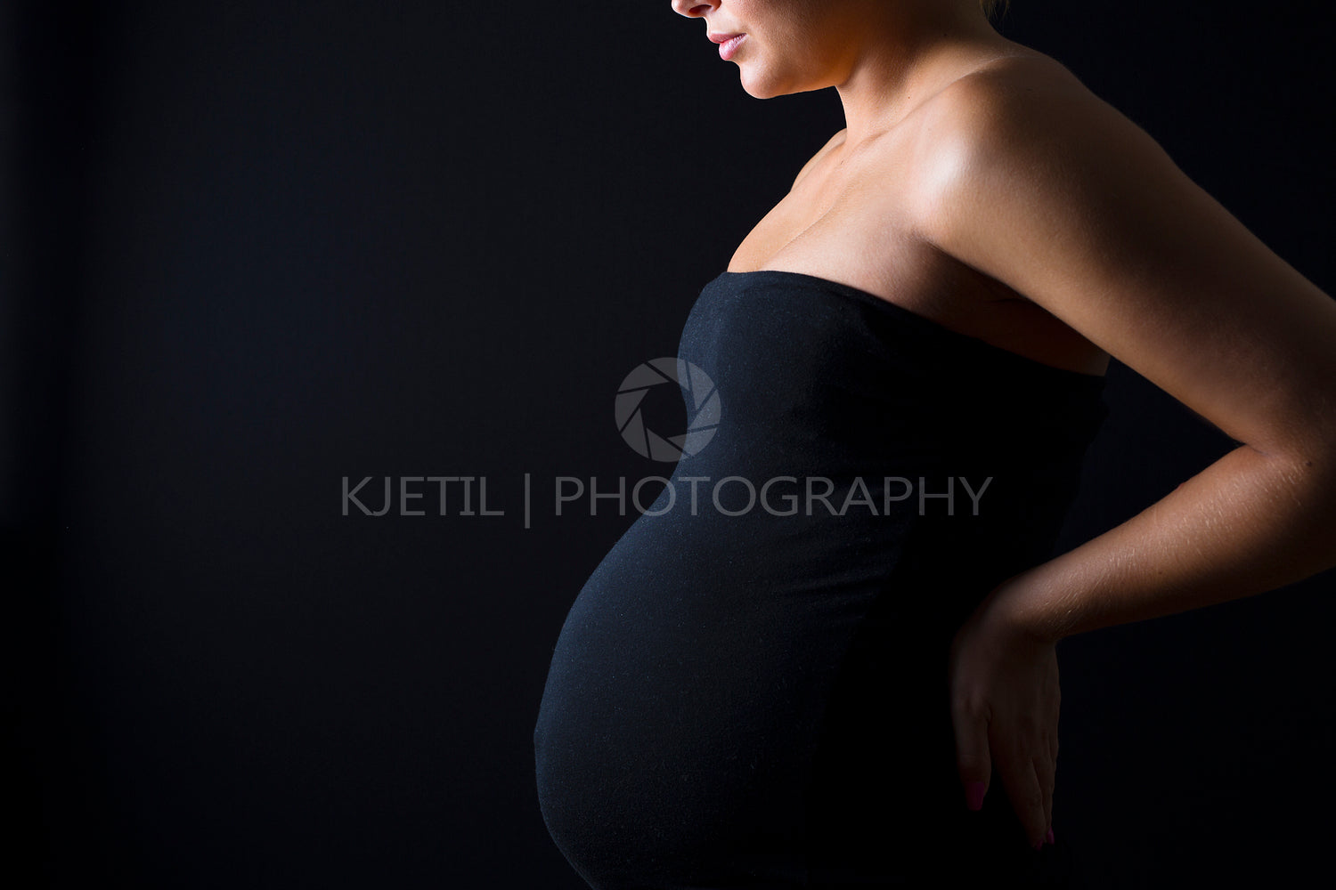 Young pregnant woman with hands on her back