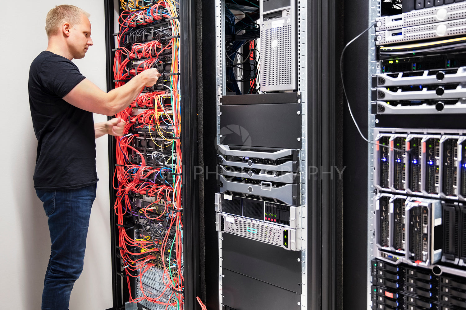 IT Consultant Working With Network Cables Connected To Servers