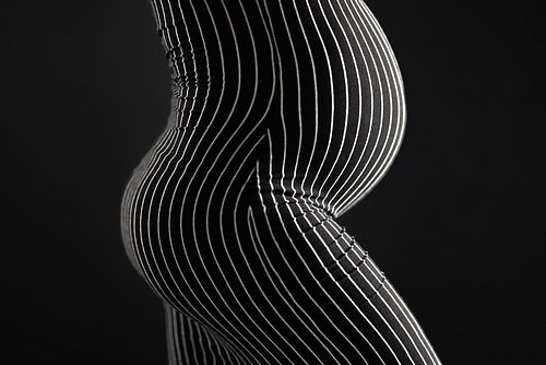 Curvy pregnant woman body in black and white striped pattern dress.