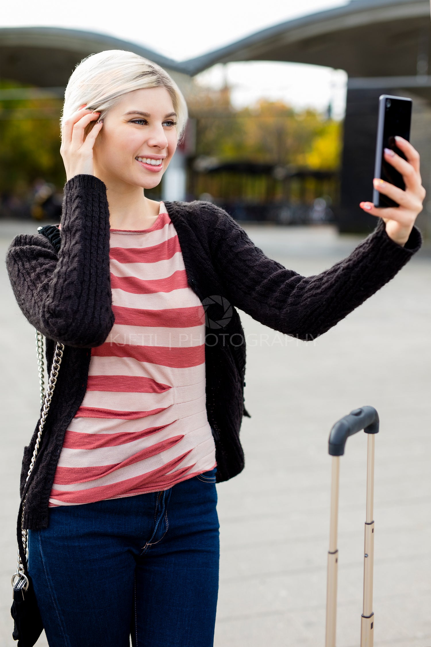 Woman Taking Selfie With Mobile Phone Outside Railroad Station