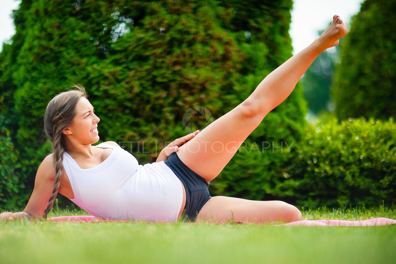 Expectant Woman Performing Side Reclining Leg Lift On Yoga Mat
