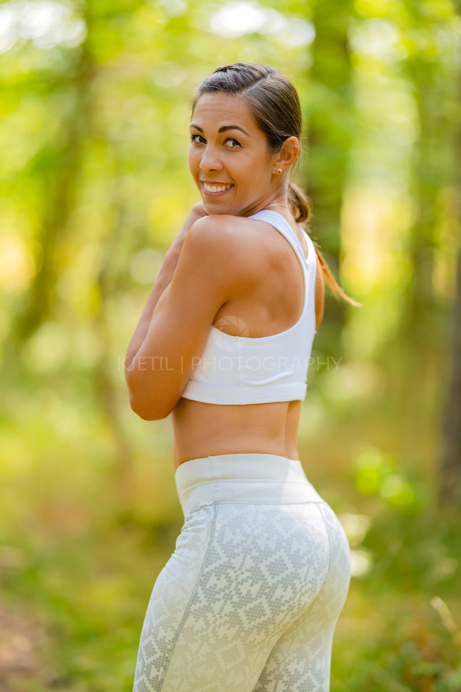 Smiling Athletic Woman In Sportswear Against Trees