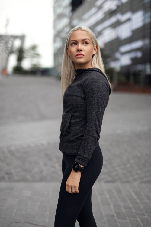 Beautiful urban scandinavian woman in workout outfit standing in city