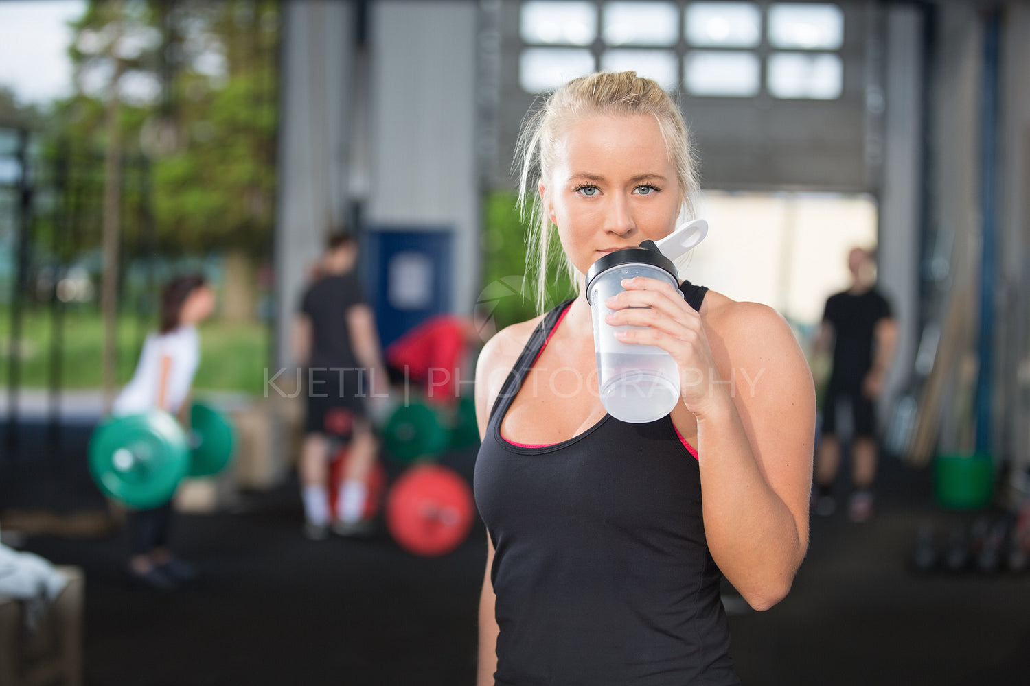 Woman drinking water at fitness gym center