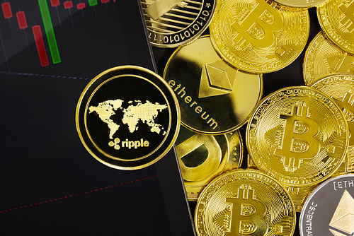 Close-up of Ripple by graph on digital tablet near various coins