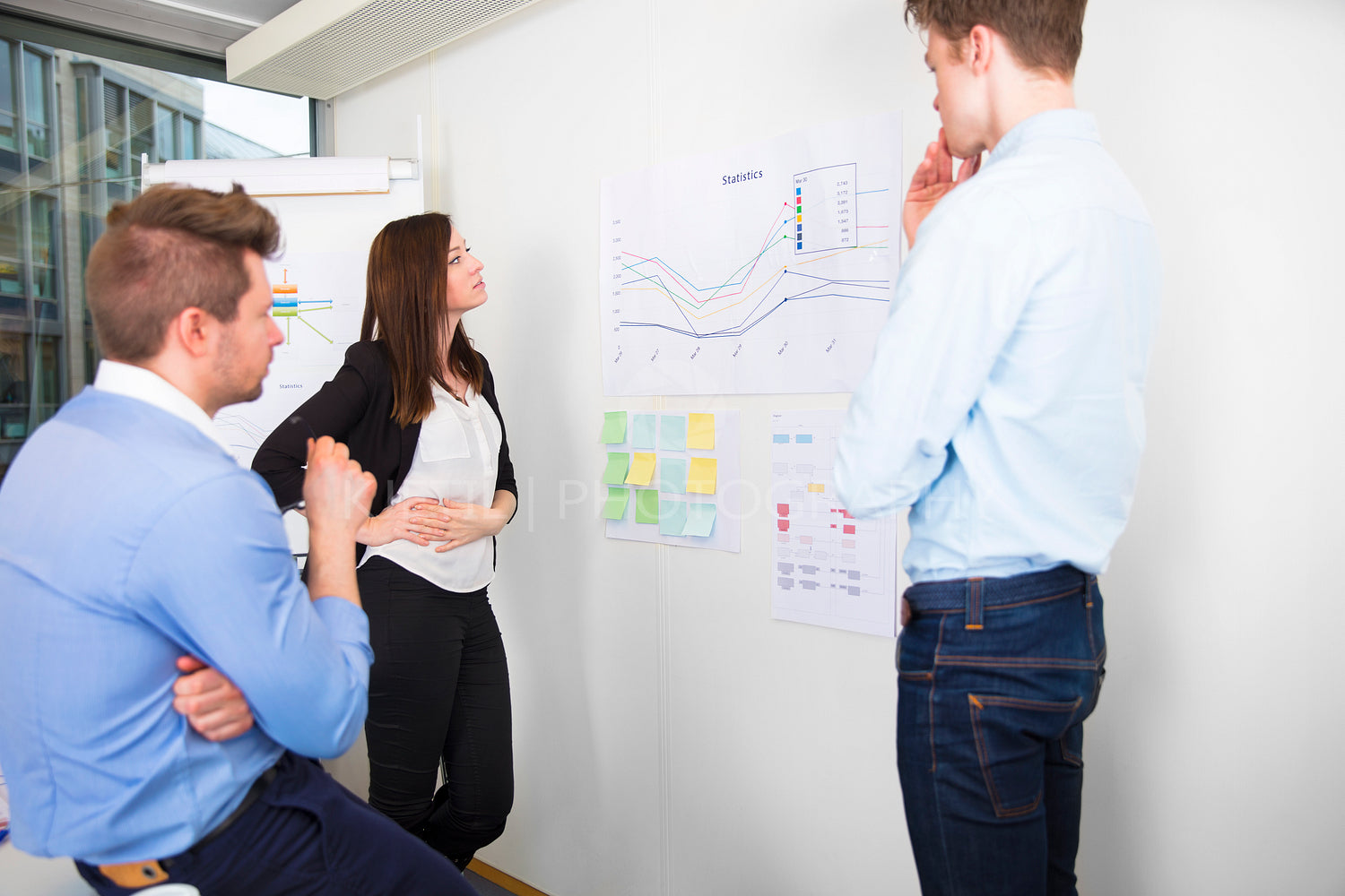 Business Professionals Discussing Over Line Graph In Office