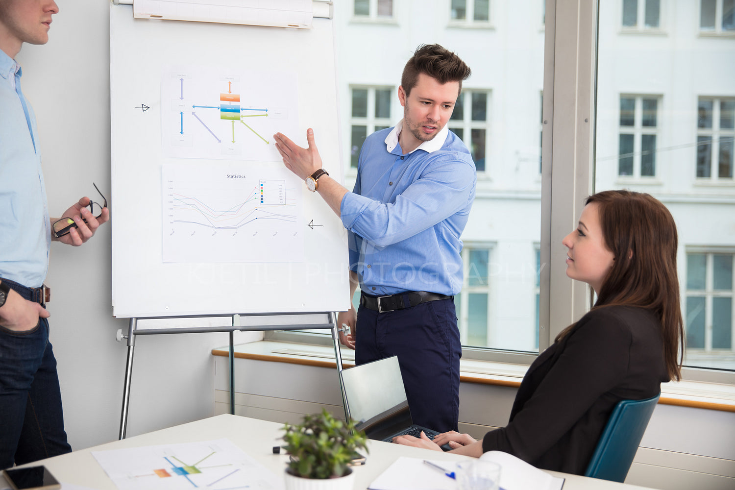 Businessman In Formals Giving Presentation To Colleagues