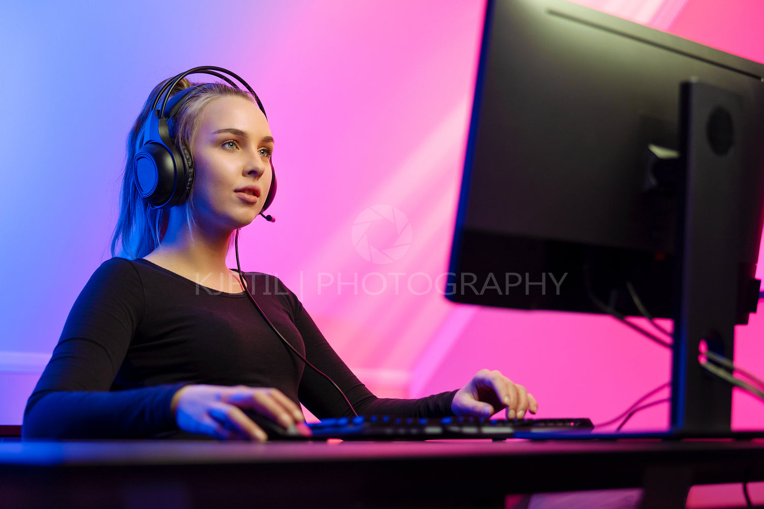 Focused Gamer Girl with Headset Playing Online Video Game on PC