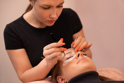 Close-up of beautician Using Tweezers During Eyelash Extension Treatment
