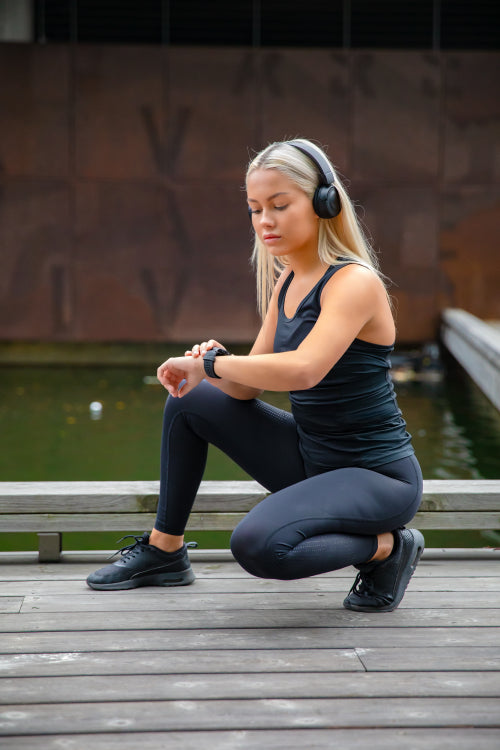 Beautiful fitness woman runner using smart watch phone