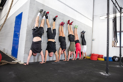 Team exercising handstands at fitness gym center
