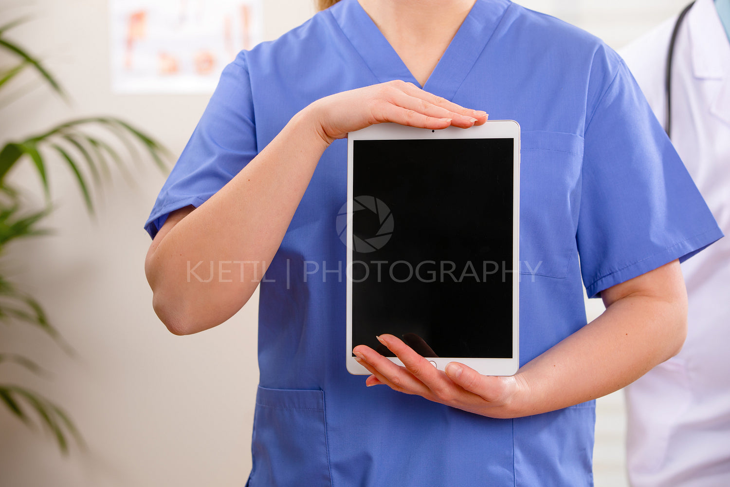 Adult female doctor or nurse showing a digital image or report on a tablet