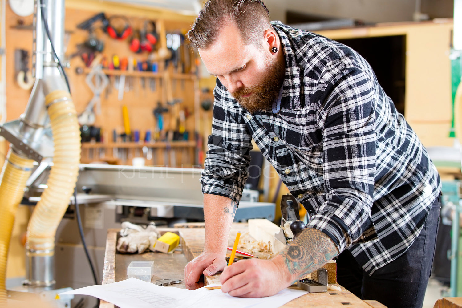 Carpenter planning work and looking at drawings in the workshop