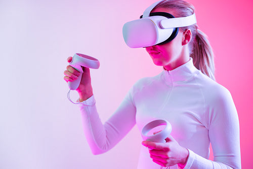Woman in VR glasses in front of colored background