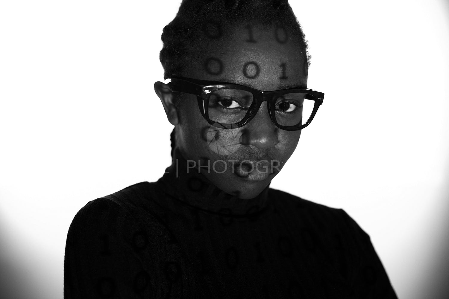 Young female hacker with digital binary code projected at her face