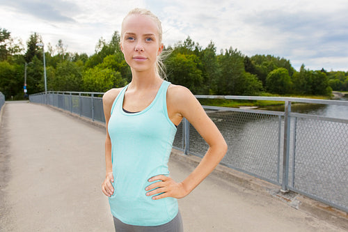 Confident woman stands at bridge after workout