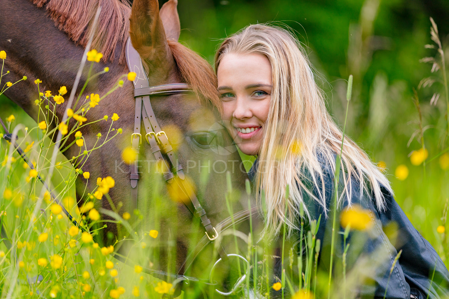 Smiling woman sitting in the meadow with her arabian horse