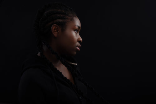 Cool and Real Black Female Model Looking Away Against Black Background