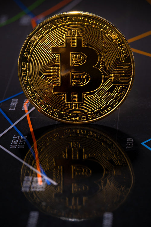 Closeup Of Gold Bitcoin Crypto Currency Coin Over Value Graph