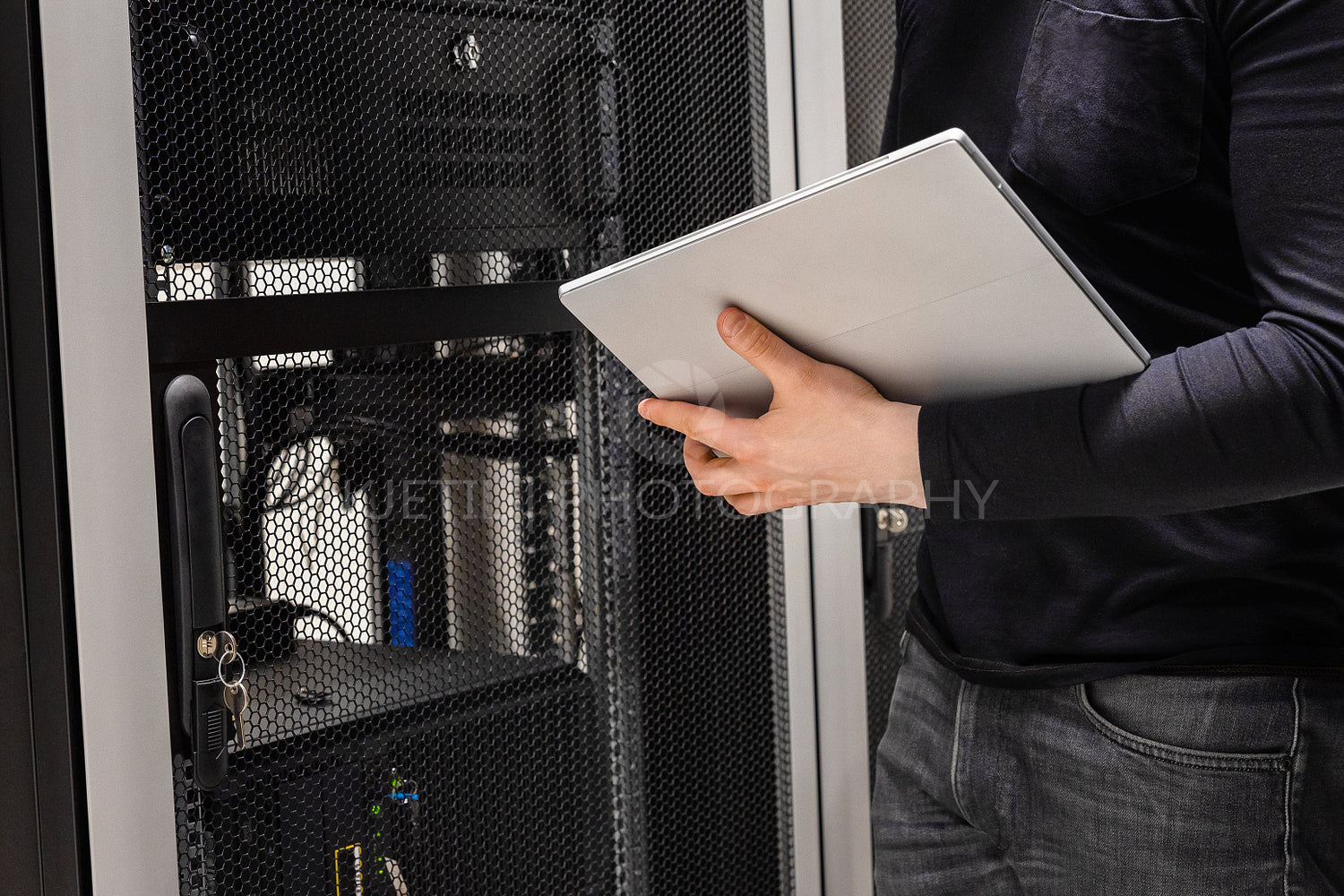 Midsection of IT Support Using Digital Tablet in Large Datacenter